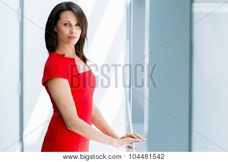 Modern business woman standing in front of window