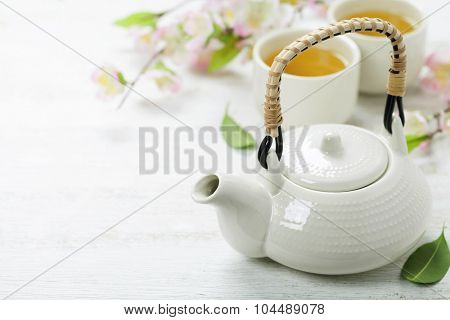 Chinese Tea Set  and sakura branch on bamboo mat