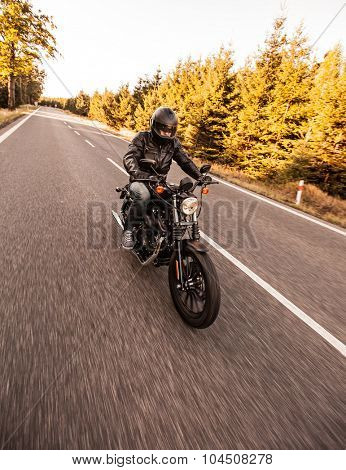 ROUSINOV - SEPTEMBER 29: Harley-Davidson Motorcycle Sportster Iron 883, drives through the forests during sunrise. September 29, 2015 in Rousinov, Czech republic.