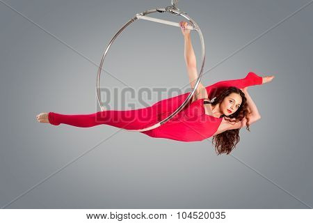 Plastic Beautiful Girl Gymnast On Acrobatic Circus Ring In Flesh-colored Suit. Aerial Ring.