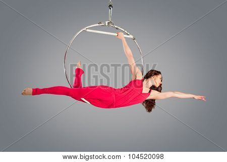 Plastic Beautiful Girl Gymnast On Acrobatic Circus Ring In Flesh-colored Suit. Aerial Ring.