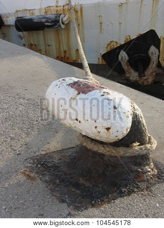 Old Rusty Bollard And Rope On A Traditional Harbor Pier