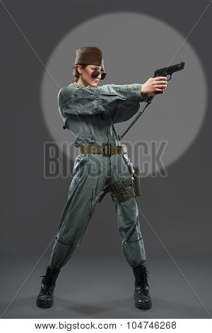 A Girl Dressed As A Helicopter Pilot With A Gun In His Hand.