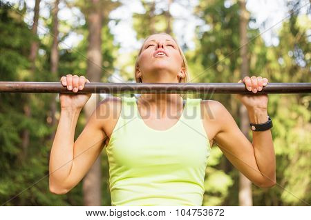 Active and young woman doing pullups