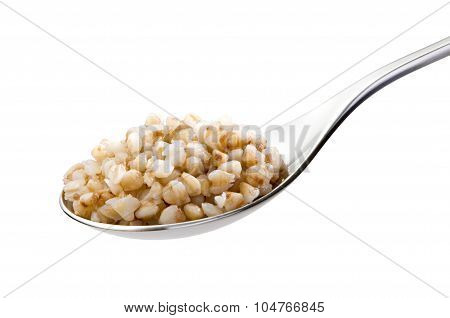 spoon with boiled buckwheat close-up isolated on white