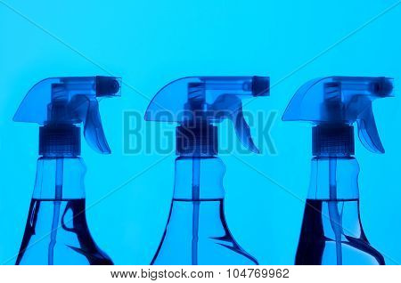 Three Spray Bottles With Blue Light