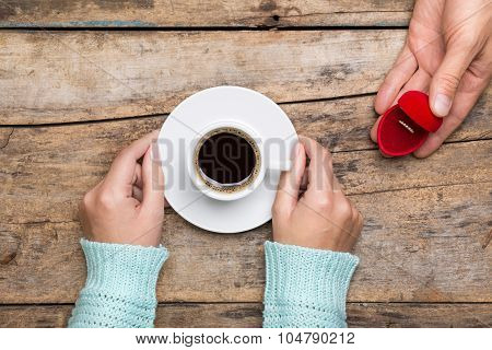 Woman Holds Cup Of Coffee And Man Gives Gold Ring As A Gift