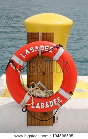 LABADEE, HAITI - SEPTEMBER 27, 2015:  Labadee, Haiti Photo Op on the Dock with an orange Life Ring next to a Hitching Post for Cruise Ships and Boats to tie to the dock.