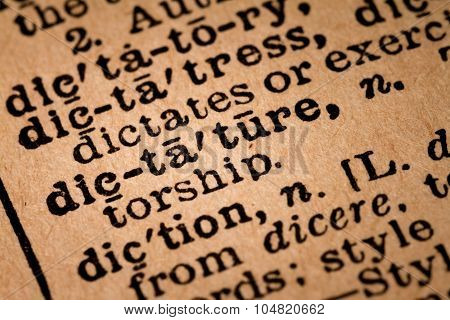 Close-up Of An Opened Dictionary Showing The Word Dictature