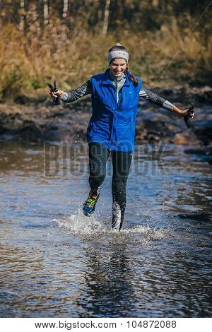 young girl athlete crossing a mountain river