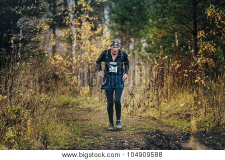 very old man athlete running in autumn forest