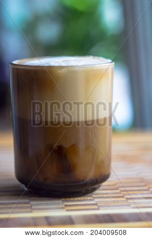 Glass cup of cappuccino on wooden table