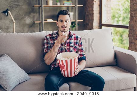 Portrait Of Impressed Brunet Attractive Hipster With Bristle In Shirt Eating Pop Corn While Watching
