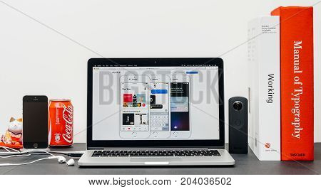 PARIS FRANCE - SEP 13 2017: Minimalist creative room table with Safari Browser open on MacBook Pro laptop showcasing Apple Computers website with latest iPhone 8 and 8 Plus with apple pay