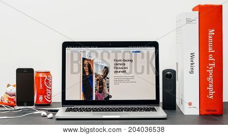 PARIS FRANCE - SEP 13 2017: Minimalist creative room table with Safari Browser open on MacBook Pro laptop showcasing Apple Computers website with latest iPhone 8 and 8 Plus with front-facing camera