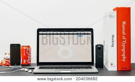 PARIS FRANCE - SEP 13 2017: Minimalist creative room table with Safari Browser open on MacBook Pro Pro laptop showcasing Apple Computers website with latest iPhone 8 and 8 Plus with glass body
