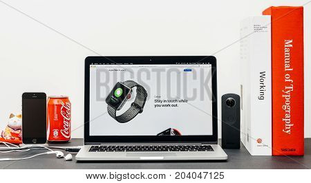 PARIS FRANCE - SEP 13 2017: Minimalist creative room table with Safari Browser on MacBook Pro laptop at Apple Computers website with latest Apple Watch Series 3 with