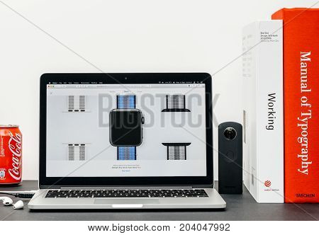 PARIS FRANCE - SEP 13 2017: Minimalist creative room table with Safari Browser open on MacBook Pro laptop at Apple Computers website with latest Apple Watch Series 3 with selction of apple watc face band