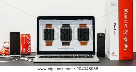 PARIS FRANCE - SEP 13 2017: Minimalist creative room table with Safari Browser open on MacBook Prolaptop at Apple Computers website with latest Apple Watch Series 3 with selction of apple watc face band