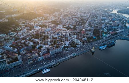 Panoramic view of a modern city at sunset. Skyline bird eye aerial view of the old part of the city - Podol district under dramatic cloud sunset sky. Kiev. Ukraine