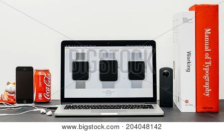 PARIS FRANCE - SEP 13 2017: Minimalist creative room table with Safari Browser open on MacBook Pro laptop at Apple Computers website with latest Apple Watch Series 3 with selction of apple watc face band
