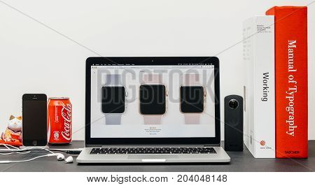 PARIS FRANCE - SEP 13 2017: Minimalist creative room table with Safari Browser open on MacBook Pro laptop at Apple Computers website with latest Apple Watch Series 3 with selction of apple watc face band