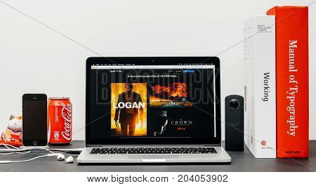 PARIS FRANCE - SEP 13 2017: Minimalist creative room table with Safari Browser open on MacBook Pro laptop showcasing Apple Computers website with latest Apple TV 4k with selction of 4k hdr movies