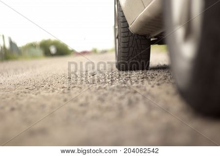 the wheel of a car on a dirt road with blurred background