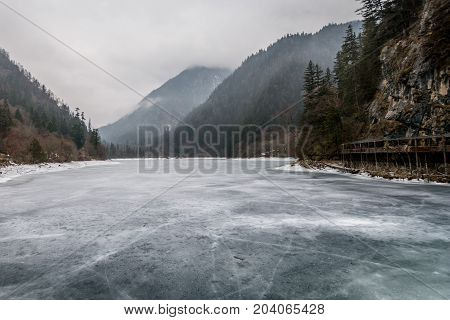 Cold river over the mountains. A frozen river over the mountains. Winter mountains over the ice river. Mountains above the sky