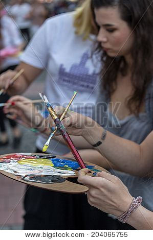TIMISOARA ROMANIA - SEPTEMBER 8 2017: Girls that painting at the street inside the CheckART Carnival organized by the City Hall Timisoara. Liberty Square.