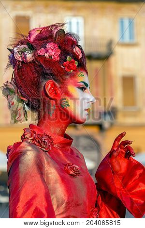 TIMISOARA ROMANIA - SEPTEMBER 8 2017: Portrait of living statue of a woman multicolor dressed and present on the street CheckART Carnival organized by the City Hall Timisoara. Union Square.