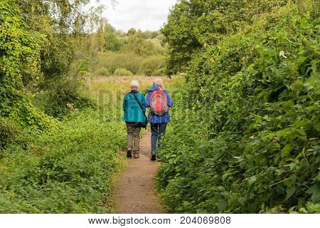 two happy senior ladies having a walk in the park among birds and wildlife.