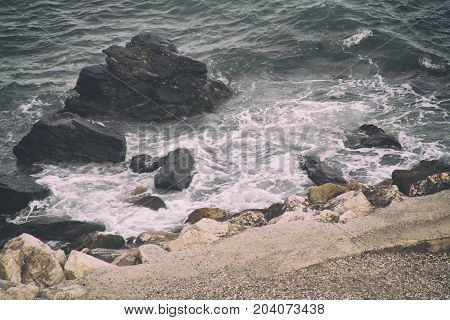 the waves crash on the huge rocks in the sea