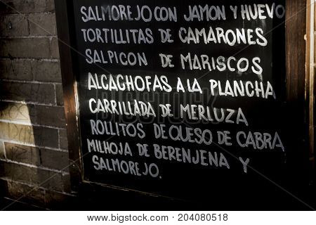 Traditional Andalusian food, slate written typical dishes Meditarranea cuisine in Seville