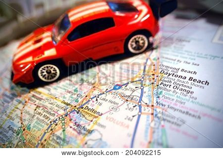 A racecar pictured with a map of Daytona Beach, Florida.