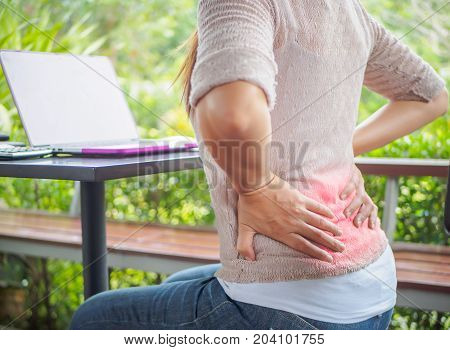 Closeup woman with hands holding her back pain. Office syndrome and Health-care Concept.