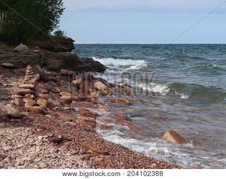 Waves of Lake Superior surge toward the rocky shore of Presque Isle Park in Marquette Michigan.