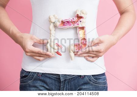 woman with colorectal cancer concept on the pink backgorund