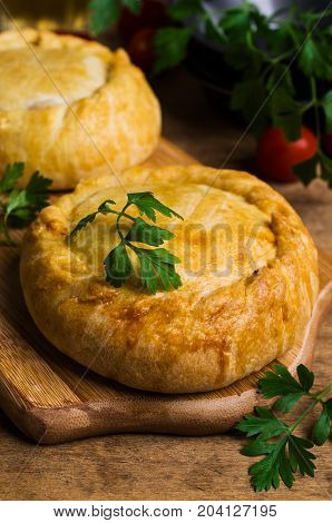 Round meat pie with vegetables and spices on a wooden background. Selective focus.
