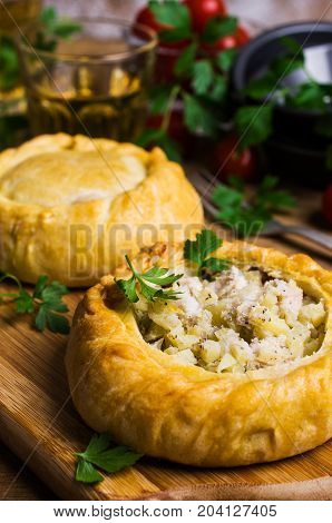 Round meat pie with vegetables and spices on a wooden background. Selective focus.