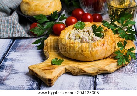 Round meat pie with vegetables and spices on a wooden background. Selective focus.