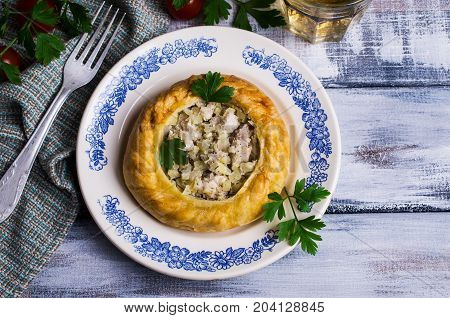 Round meat pie with vegetables and spices on a wooden background. Selective focus.