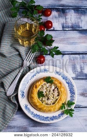 Round meat pie with vegetables and spices on a wooden background. Selective focus.
