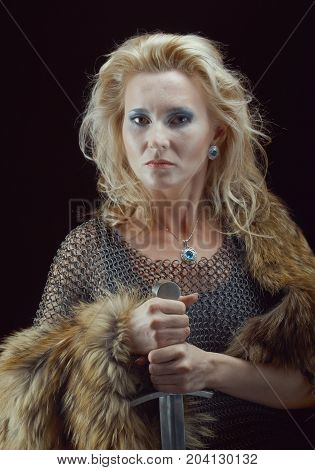 Valkyrie. Viking girl posing performance with sword