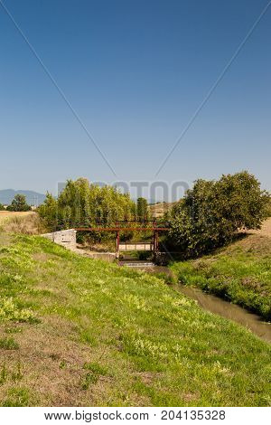 Irrigational canal in picturesque rural area with open watergate