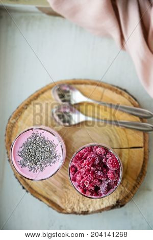 Chia and frozen raspberies cottage cheese breakfast in two small transparent glasses