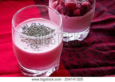 Chia and frozen raspberies cottage cheese breakfast in two small transparent glasses