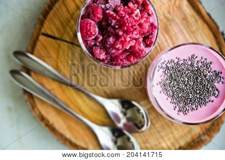 Chia and frozen raspberies cottage cheese breakfast in two small transparent glasses