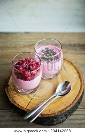 Chia and frozen raspberies cottage cheese breakfast in two small transparent glasses