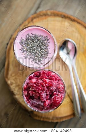 Chia and frozen raspberies cottage cheese breakfast in two small transparent glasses